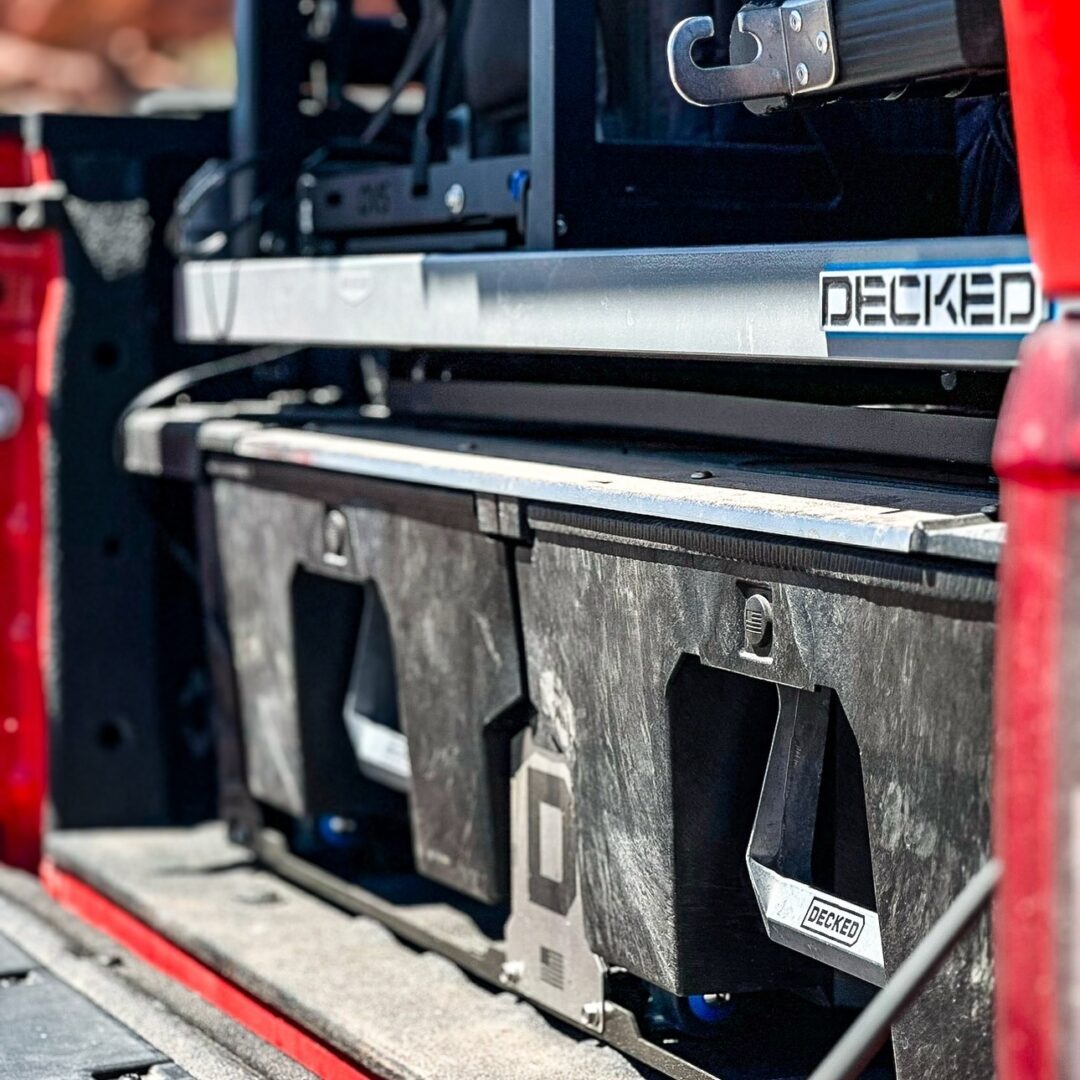 Durable storage boxes secured in a vehicle bed with metal rails.