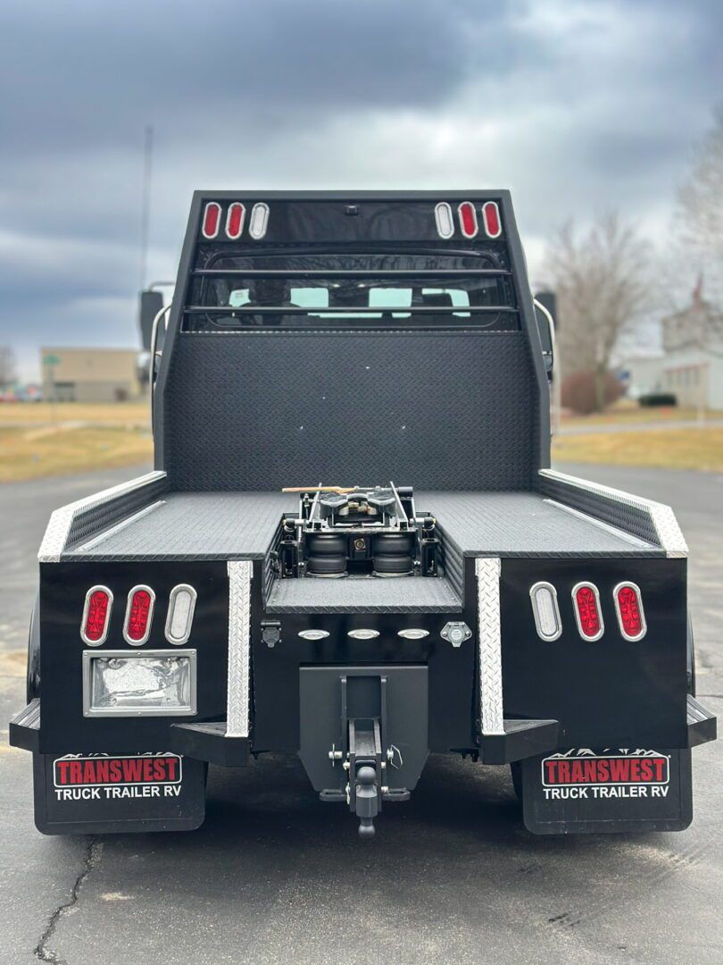 Rear view of a heavy-duty truck with lights and hitch setup.