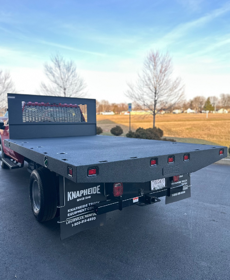 Flatbed truck parked outdoors on a clear day.